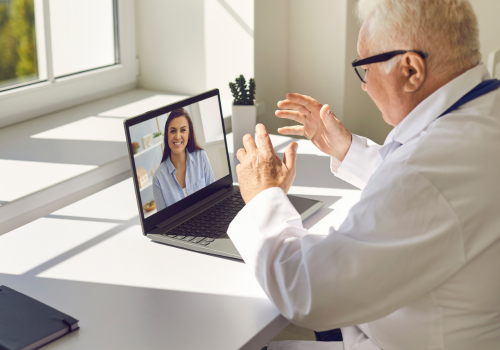 Médico em consulta de telemedicina com paciente no laptop